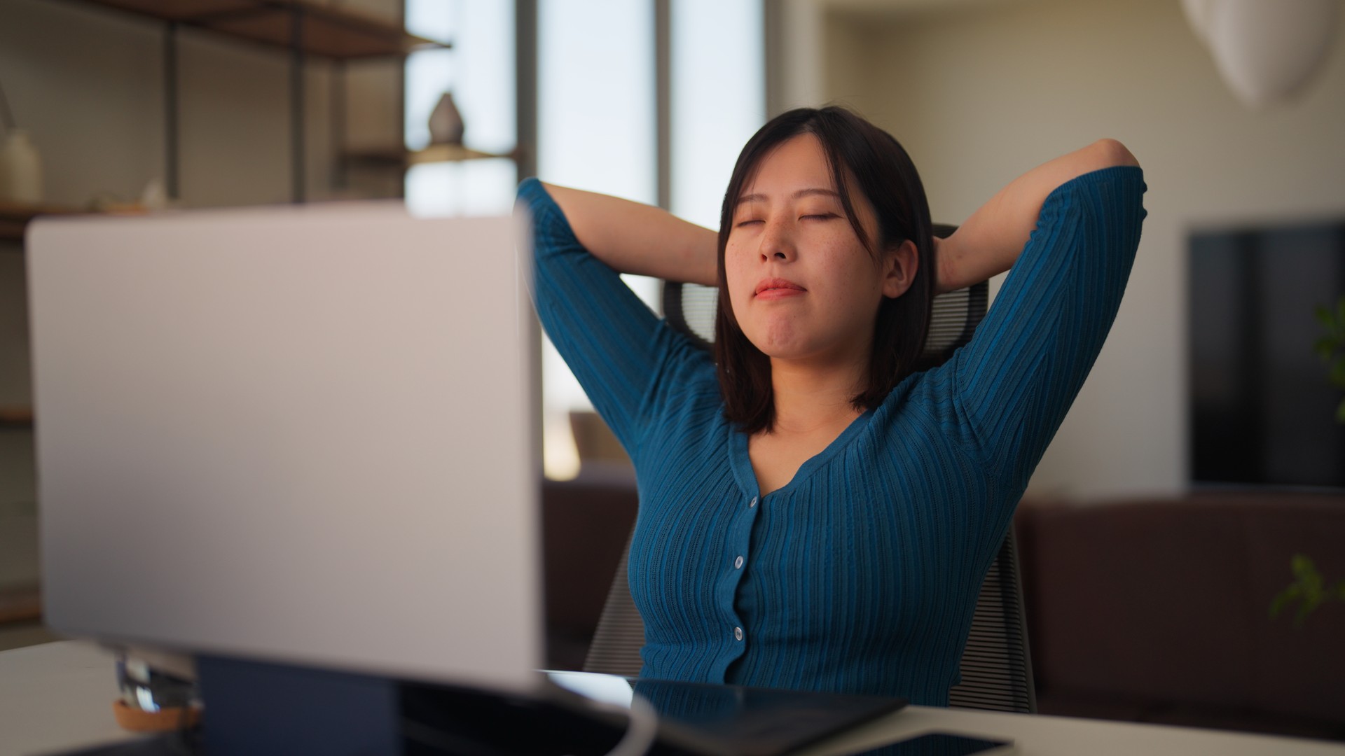 Freelancer businesswoman taking break from working and relaxing and doing breathing exercise in living room at home